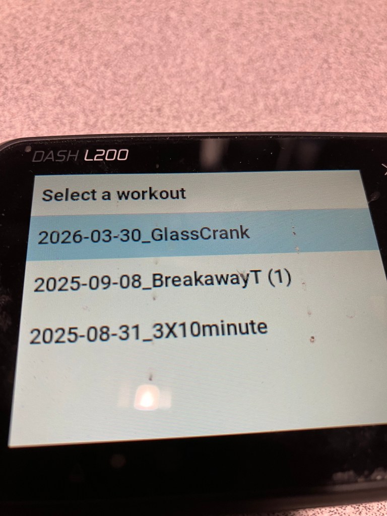 Display screen of a DASH L200 device showing the option to select a workout with listed dates and names of workouts.